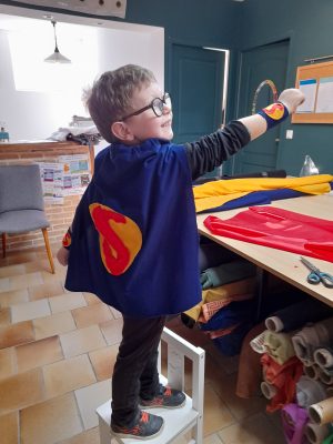 un enfant heureux avec la cape de super héros qu'il a fabriqué