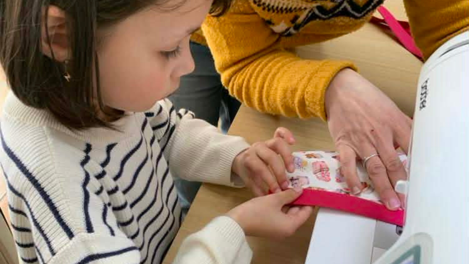 une petite fille réalise son premier cour de couture